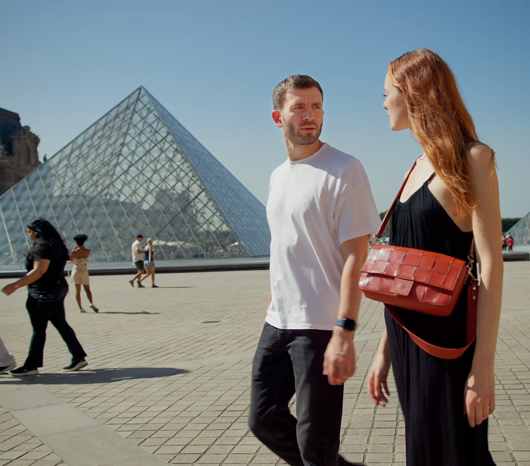 portfolio-1 A young couple walks in front of the pyramid at the Louvre Museum